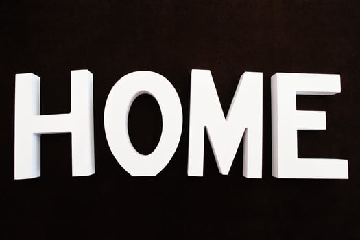 White wooden letters HOME at black background photo