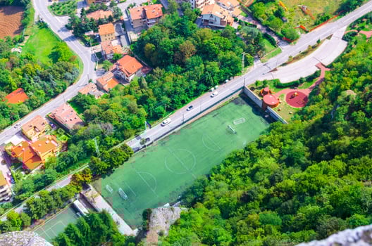 Top view from above of football stadium green grass lawn field and trees photo