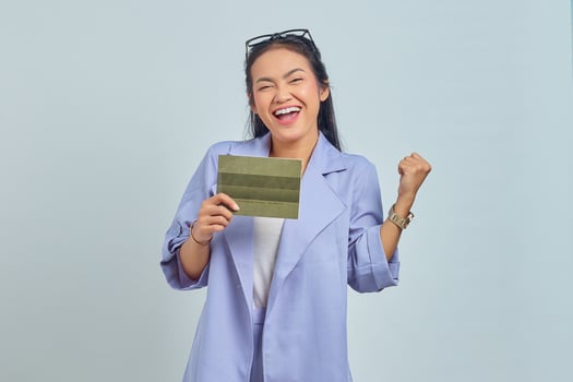 Portrait of cheerful young Asian woman showing vehicle book and celebrating happiness isolated on white background photo