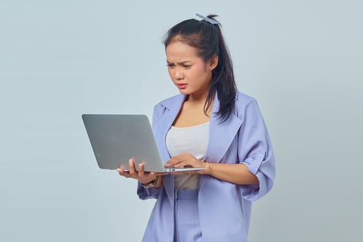 Portrait of surprised young Asian business woman looking at incoming email on laptop isolated on white background photo
