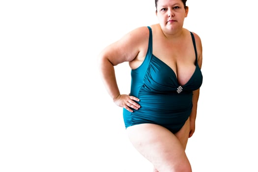 young woman posing in a turquoise swimwear on white background photo