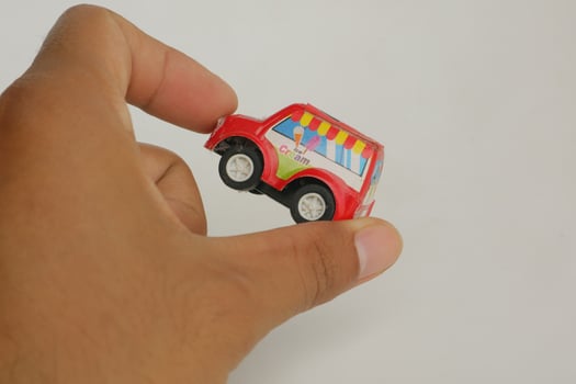 hand holding a small red toy car photo
