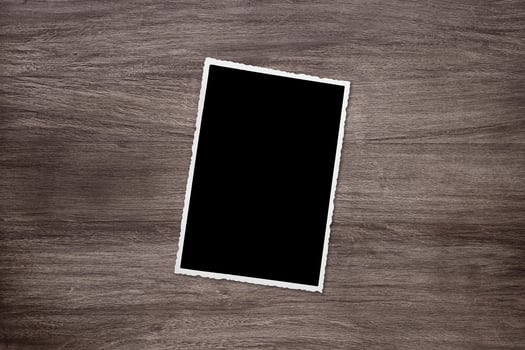 blackened old vintage photo template on wooden background