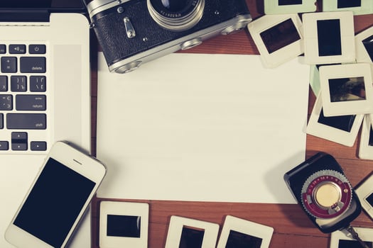 retro camera and some old photos on wooden table.
