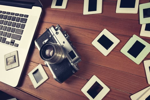 composition of old photo camera, laptop and slides