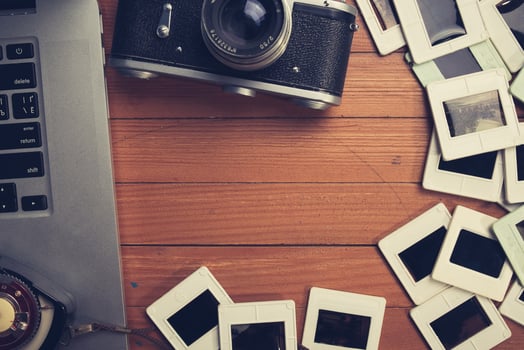 composition of old photo camera, laptop and slides