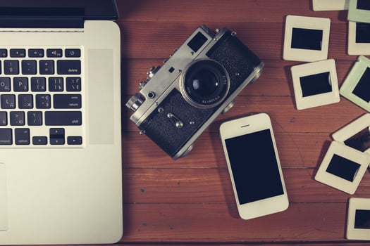 retro camera and some old photos on wooden table.