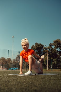 Beautiful blonde doing stretching on the lawn of a football field photo