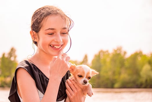 Teen girl and chihuahua dog in her arms. Beautiful girl near the river. photo
