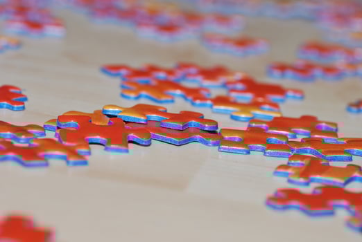 many puzzle pieces are scattered on a wooden floor photo