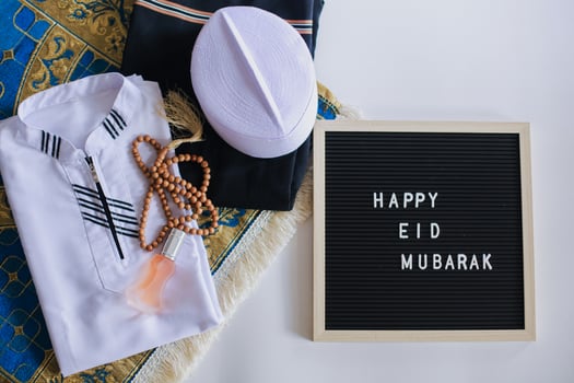 Top view of Muslim traditional dress and prayer beads on the prayer mat with letter board says Happy Eid Mubarak photo