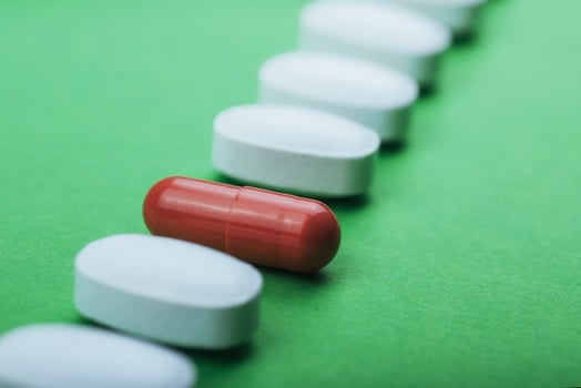 Medical white pills and brown capsules for the treatment and health care on a green background photo