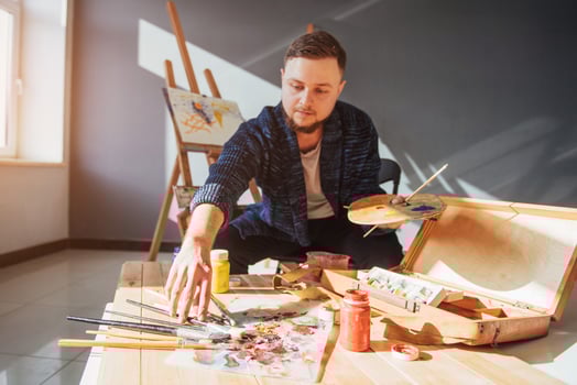 Designed by artist man finishing his masterpiece holds a brush in hand. photo