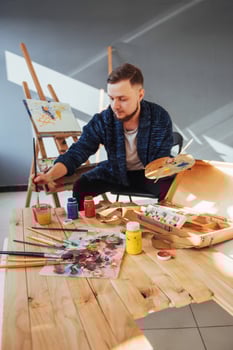 Designed by artist man finishing his masterpiece holds a brush in hand. photo