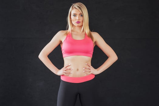 Sexy girl in sportswear with a smile posing for the camera in a sports hall photo