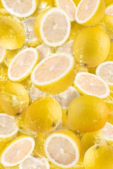 Water splashing on Sliced lemon fruit isolated on yellow background photo