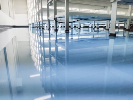 a cable under rack legs at sea blue epoxy floor.Industrial epoxy floor photo