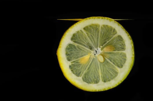 lemon in the water under surface black photo