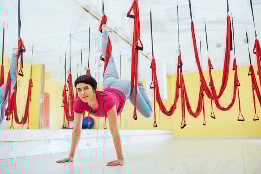 Young beautiful woman practicing yoga Fly with a hammock in the bright studio. Flying, fitness, stretch, balance, exercise. photo