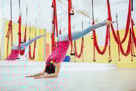 young woman making antigravity yoga exercises photo