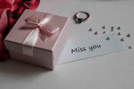 Note miss you with gift box, ring and handkerchief on white background photo