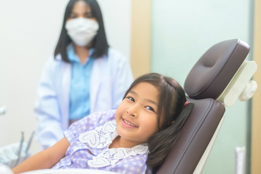 A little cute girl having teeth examined by dentist in dental clinic, teeth check-up and Healthy teeth concept photo