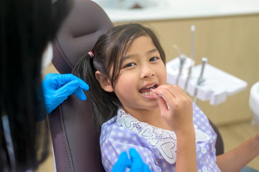 A little cute girl having teeth examined by dentist in dental clinic, teeth check-up and Healthy teeth concept photo