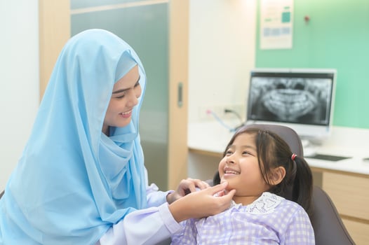A little cute girl having teeth examined by muslim dentist in dental clinic, teeth check-up and Healthy teeth concept photo