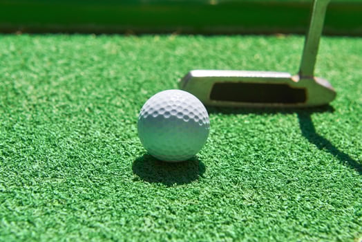 Mini-golf ball on artificial grass. Summertime. photo