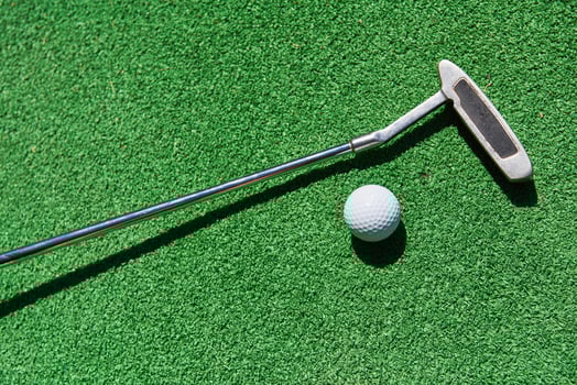Mini-golf ball on artificial grass. Summertime. photo