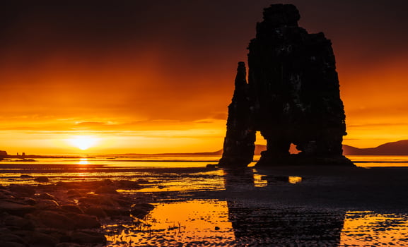 Is a spectacular rock in the sea on the Northern coast of Iceland. Legends say it is a petrified troll. On this photo Hvitserkur reflects in the sea water after the midnight sunset.