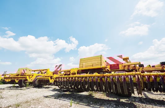 Close up of seeder attached to tractor in field. Agricultural machinery for spring works sowing photo