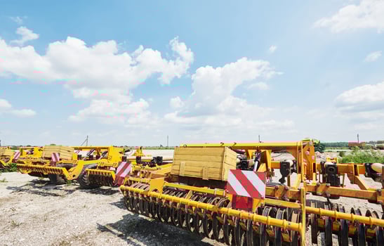 Close up of seeder attached to tractor in field. Agricultural machinery for spring works sowing photo
