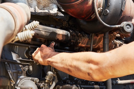 Combine machine service, mechanic repairing motor outdoors photo