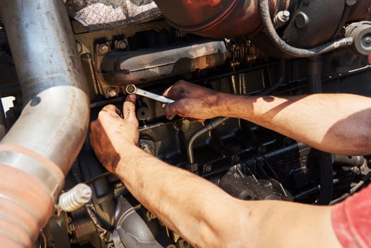 Combine machine service, mechanic repairing motor outdoors photo