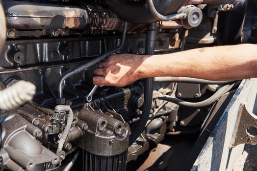 Combine machine service, mechanic repairing motor outdoors photo