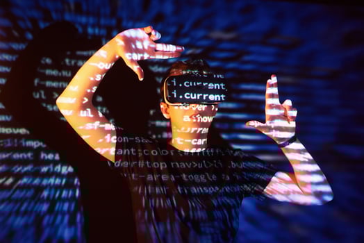 Double exposure of a caucasian man and Virtual reality headset is presumably a gamer or a hacker cracking the code into a secure network or server, with lines of code photo