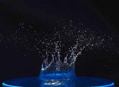 Splash of water crown on blue surface. photo