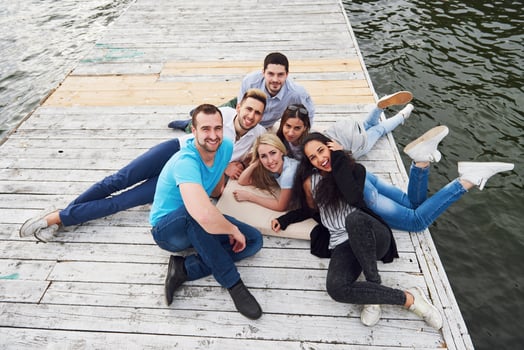 Group of beautiful young people on the pier, friends satisfaction creates emotional life photo