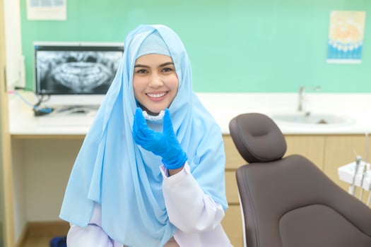 Young female muslim dentist holding invisalign in dental clinic, teeth check-up and Healthy teeth concept photo