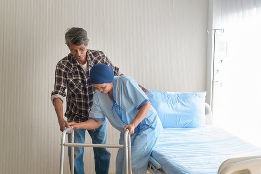 Senior man helping cancer patient woman wearing head scarf with walker at hospital, health care and medical concept photo