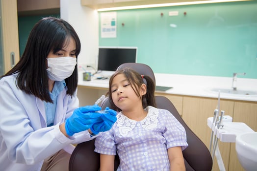 Female dentist showing invisalign to a little girl in dental clinic, teeth check-up and Healthy teeth concept photo