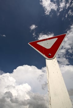 Yeild sign with Cumuloninumbus clouds in background photo