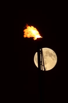 Full moon behind natural gas flame photo