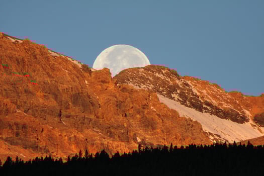 Full moon behind mountain in scenic Alberta photo