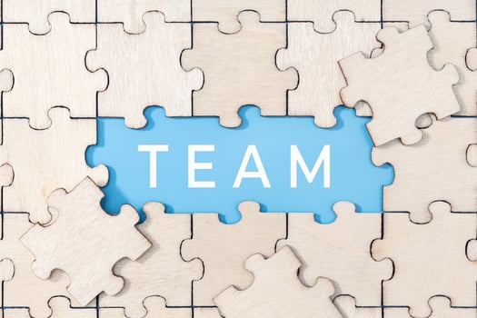 Team word on blue background surrounded by puzzle pieces photo
