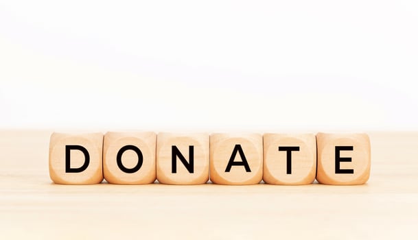 Donate word on wooden block shape. Copy space. White background photo
