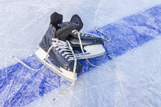 Sports black skates are on the hockey court. Winter Sports Equipment photo