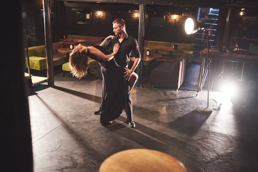 Skillful dancers performing in the dark room under the light photo