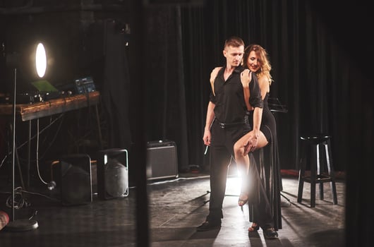Skillful dancers performing in the dark room under the light photo